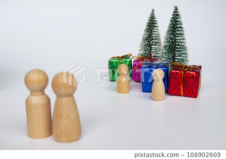 Father and mother giving out presents to their children during Christmas celebration 108902609