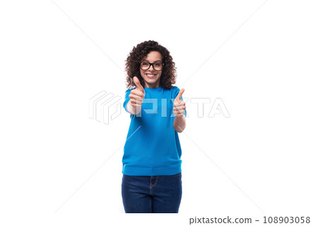 young happy woman dressed in a blue t-shirt made curly hair styling 108903058