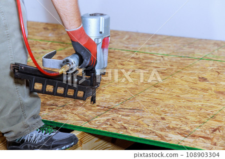 New home with installation wooden plywood to floor using air nail gun New home with installation wooden plywood to floor using air nail gun 108903304