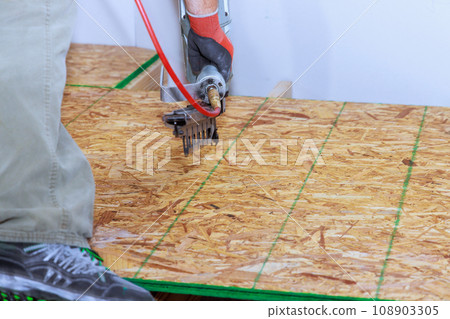 Air nail gun were used to install wooden plywood floor in new home Air nail gun were used to install wooden plywood floor in new home 108903305
