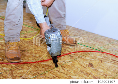 New home installation wooden plywood using an air nail gun 108903307