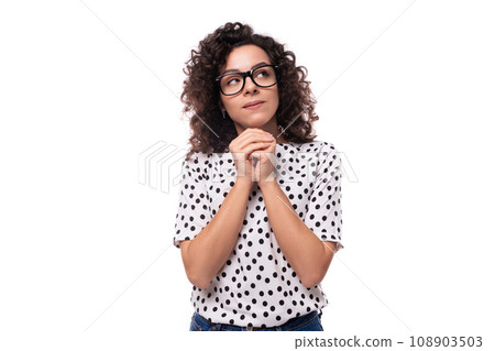 portrait of a young slender caucasian business woman with curly black hair dressed in a summer 108903503