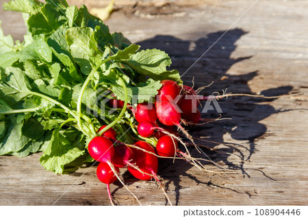 Fresh red radish with leaves on rustic wooden table 108904446