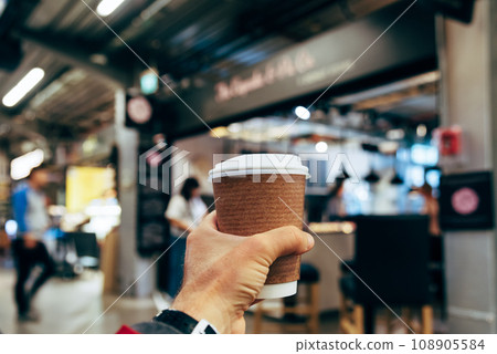 Male hand holding a paper cup of hot coffee 108905584