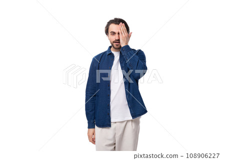 young european brunette man with a cool hairstyle is dressed in a blue denim shirt over a t-shirt young european brunette man with a cool hairstyle is dressed in a blue denim shirt over a t-shirt 108906227