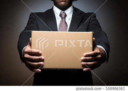 Сoncept of dismissal from work. Сlose-up cardboard box held by an sad former office worker 108906361