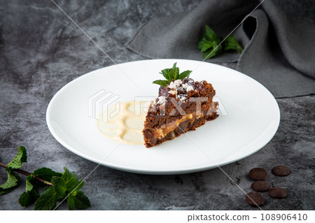 gluten free chocolate cake with nuts, berries and mint on a white plate gluten free chocolate cake with nuts, berries and mint on a white plate 108906410