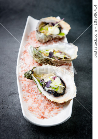 Grilled oysters on red sea salt with lime Grilled oysters on red sea salt with lime 108906414