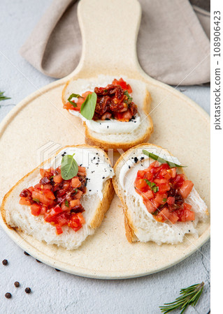bruschetta with tomatoes and labneh cheese on a light background 108906423