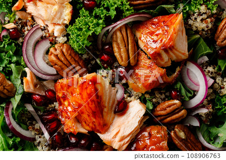 Salmon superfood salad background with grilled fish, kale, quinoa, pecan nuts, red onion and pomegranate. Top view 108906763