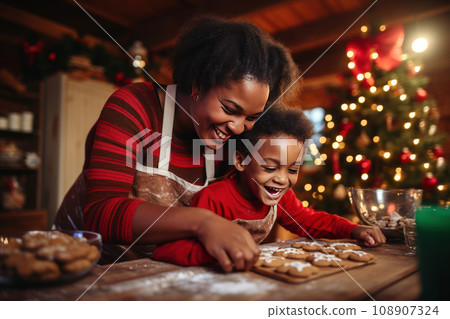 Cooking traditional Christmas cookies, mother and son together baking gingerbread for holiday at Xmas decorated kitchen. Cooking traditional Christmas cookies, mother and son together baking gingerbread for holiday at Xmas decorated kitchen. 108907324