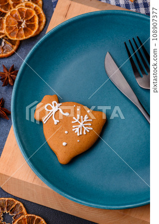 Beautiful festive Christmas composition of an empty plate, tangerine and gingerbreads Beautiful festive Christmas composition of an empty plate, tangerine and gingerbreads 108907377