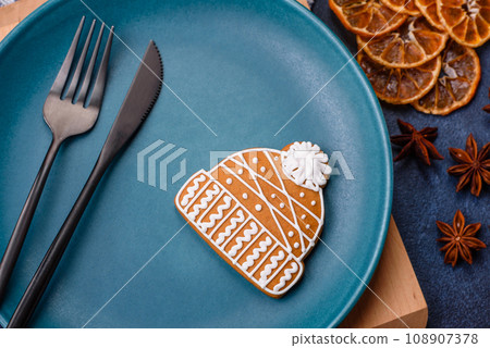 Beautiful festive Christmas composition of an empty plate, tangerine and gingerbreads Beautiful festive Christmas composition of an empty plate, tangerine and gingerbreads 108907378