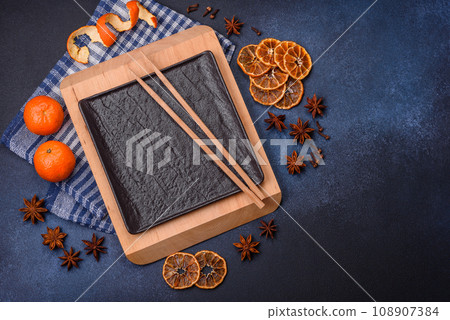 Beautiful festive Christmas composition of an empty plate, tangerine and gingerbreads Beautiful festive Christmas composition of an empty plate, tangerine and gingerbreads 108907384