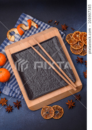 Beautiful festive Christmas composition of an empty plate, tangerine and gingerbreads 108907385