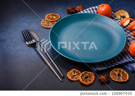 Beautiful festive Christmas composition of an empty plate, tangerine and gingerbreads 108907450