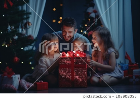 happy family with Merry Christmas magic gift near tree at evening at home 108908053