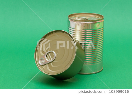 Unopened Tin Cans with Blank Edges on Green Background Unopened Tin Cans with Blank Edges on Green Background 108909016