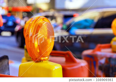 Construction warning yellow light on barricade intended to warn of in construction site Construction warning yellow light on barricade intended to warn of in construction site 108909361