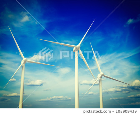Vintage retro effect filtered hipster style image of green renewable energy concept - wind generator turbines in sky Vintage retro effect filtered hipster style image of green renewable energy concept - wind generator turbines in sky 108909439