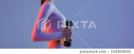 Side view of fitness woman doing exercises with dumbbells on studio background Side view of fitness woman doing exercises with dumbbells on studio background 108909690