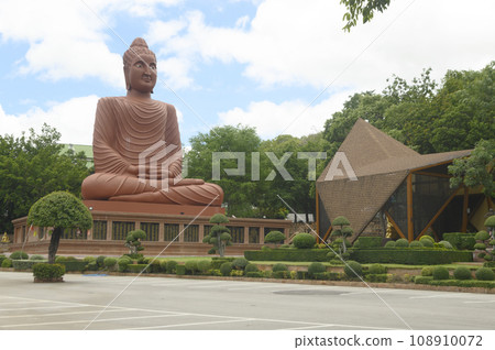 A large sandstone Buddha statue sitting outdoors at Tham Phu Wa Temple is a form of Thai art. It is reddish brown. It has a very beautiful and intricate pattern. Located at Kanchanaburi in Thailand. A large sandstone Buddha statue sitting outdoors at Tham Phu Wa Temple is a form of Thai art. It is reddish brown. It has a very beautiful and intricate pattern. Located at Kanchanaburi in Thailand. 108910072