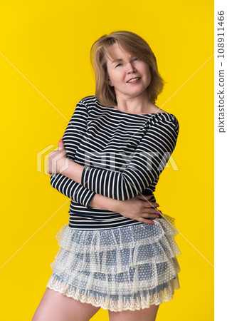 Portrait curvy smiling woman mid adult blondie in long sleeve shirt and mini skirt with arms crossed Portrait curvy smiling woman mid adult blondie in long sleeve shirt and mini skirt with arms crossed 108911466