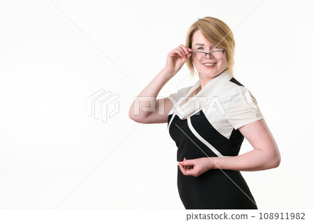 Portrait of feminine mature businesswoman with glasses looking at camera and lowering her glasses Portrait of feminine mature businesswoman with glasses looking at camera and lowering her glasses 108911982