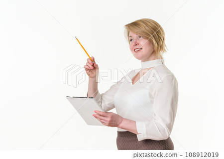 Portrait of happy mature businesswoman holding clipboard and pointing finger with pencil away 108912019
