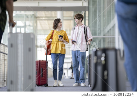 年輕的外國男女帶著手提箱旅行入境形象 年輕的外國男女帶著手提箱旅行入境形象 108912224