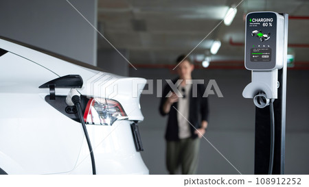 Young man travel with EV electric car to shopping center parking lot innards 108912252