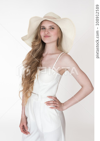Portrait of model wearing her new clothes, to dress up straw hat, white cupped corset top, trousers Portrait of model wearing her new clothes, to dress up straw hat, white cupped corset top, trousers 108912589