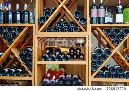 Elegant Wooden Wine Rack Filled with a Selection of Exquisite Expensive Wines 108912729