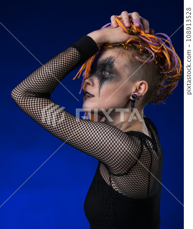Cinematic portrait of beauty woman with colored braids hairdo, spooky stage make-up painted on face Cinematic portrait of beauty woman with colored braids hairdo, spooky stage make-up painted on face 108913528