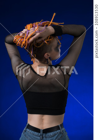 Rear view of young woman with colored braids hairdo and horror black stage make-up painted on face 108913530