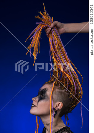 Fine art portrait of beautiful young female with orange color dreadlocks hairstyle and horror makeup 108913541