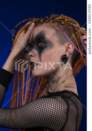 Beautiful adult female with dreadlocks hairstyle, creative horror black stage makeup painted on face 108913560