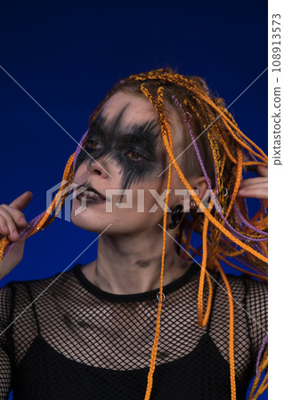Cinematic portrait of young woman with art stage make-up and colored safe dreadlocks hairstyle Cinematic portrait of young woman with art stage make-up and colored safe dreadlocks hairstyle 108913573