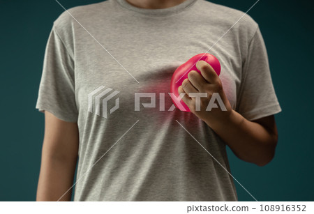 Painful, Heart Attack Concept. Young Adult Woman Squeezed a Red Balloon against her Chest. Heart Disease or feeling very Heartbreak and Sorrow 108916352