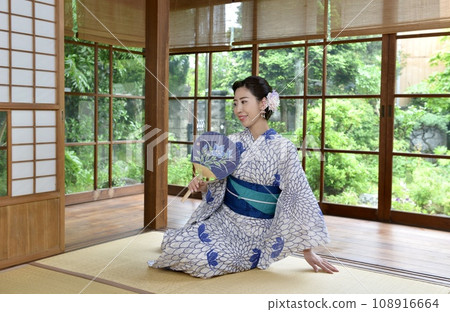 A young woman wearing a yukata in a Japanese-style room in an old folk house 108916664