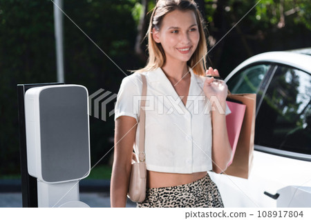 Young woman travel with EV electric car in green sustainable city innards Young woman travel with EV electric car in green sustainable city innards 108917804