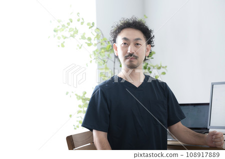 Male doctor wearing scrubs, serious expression looking at the camera 108917889