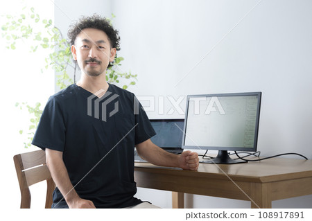 Male doctor wearing scrubs, serious expression looking at the camera Male doctor wearing scrubs, serious expression looking at the camera 108917891