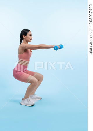 Vigorous energetic woman doing yoga with dumbbell weight exercise. 108917906