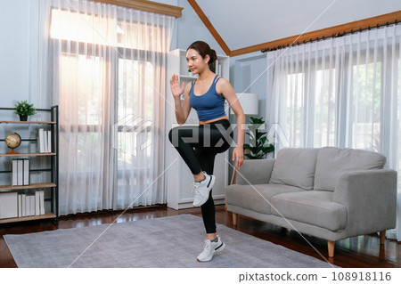 Energetic and strong athletic asian woman running in place at her home. Vigorous 108918116