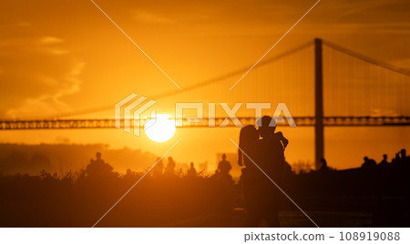 Sunset Silhouette: Two People have hag and kiss in Front of a big Bridge Sunset Silhouette: Two People have hag and kiss in Front of a big Bridge 108919088