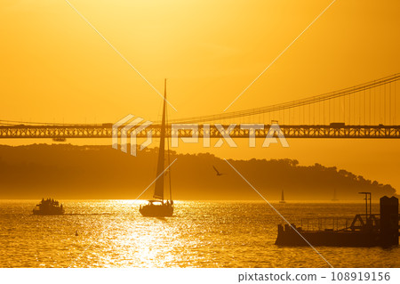 Sunset Reflections on Majestic Bridge Over Vast Ocean Waters Sunset Reflections on Majestic Bridge Over Vast Ocean Waters 108919156
