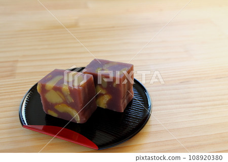 Chestnut steamed yokan served in a half-moon tray on a wooden table Chestnut steamed yokan served in a half-moon tray on a wooden table 108920380