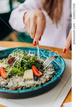 Close up of woman eating beef carpaccio with pesto sauce and parmigiano cheese. Restaurant menu 108922508