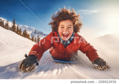 Cheerful kid sliding downhill in winter sunshine. AI content 108922650